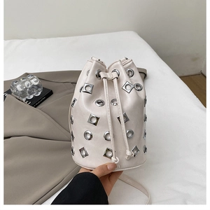 Détail du sac seau blanc cassé avec œillets métalliques argentés et cordon de serrage