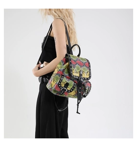 Detail of colorful snakeskin pattern backpack with silver rivets and metallic studs