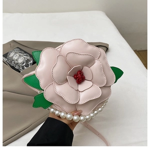 Detail of 3D pink flower purse with layered petals, pearl handle and green leaf accent