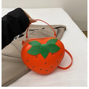 Vue détaillée du sac fraise avec feuilles à paillettes vertes et clous métalliques