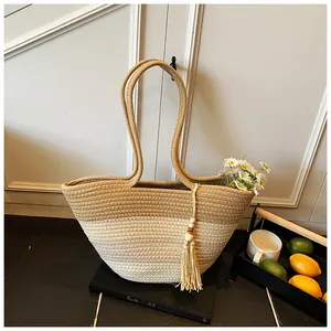 Detail of color-block woven tote bag with bohemian tassels and wooden bead accents