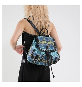 Detailed close-up of blue faux snakeskin backpack featuring silver rivet studs and metal buckle