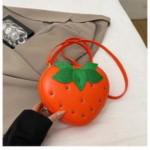 Détail du sac bandoulière en forme de fraise avec feuille verte et perles noires