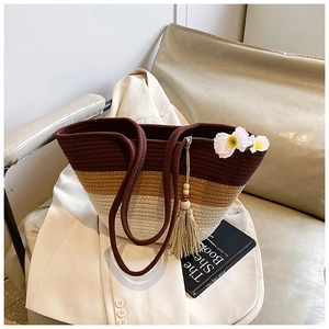 Detail of a large woven tote bag with three-color contrast and wooden bead tassel