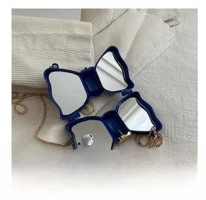 Mini sac papillon bleu avec miroir intérieur montrant l'espace pour écouteurs sans fil