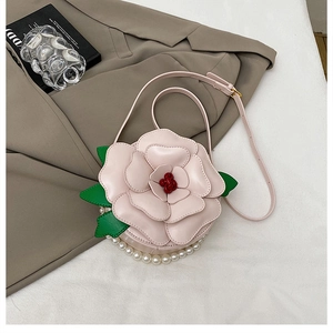 Close-up of pink 3D flower-shaped bag with green leaves and elegant pearl details