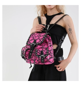 Close-up of pink snakeskin backpack with silver studs and black leather trim details