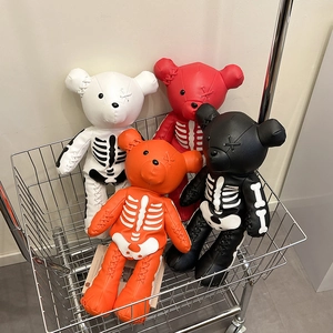 Japanese style cartoon skeleton teddy bear backpacks in multiple colors shown in a cart