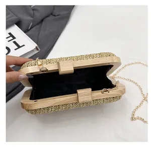 Detail view of woven straw clutch with wooden frame and spacious fabric lining