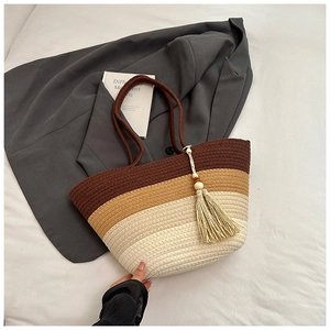 Close-up of woven tote bag with three-color segments, tassels, and detailed texture