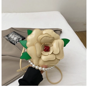 Detail of flower shaped crossbody bag featuring cream leather petals and pearl handle