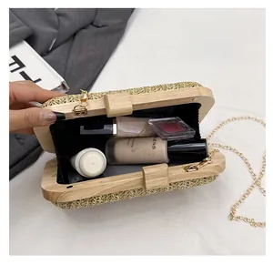 Detail view of woven clutch interior with wooden frame and golden chain strap