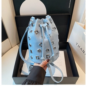 Gros plan d'un sac seau bleu clair avec des œillets argentés et des clous punk
