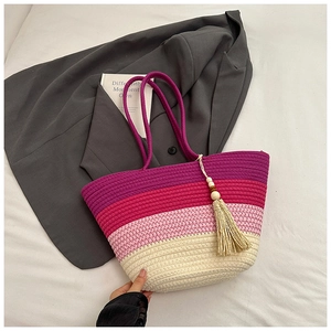 Close-up of colorful striped woven tote bag with fringe tassels and wooden beads