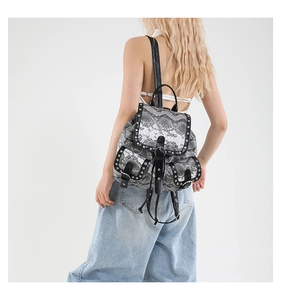 Detail of snake print backpack featuring silver studs and front buckle pockets on a model