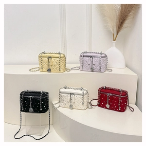 Detail of five quilted crossbody bags with chain straps and camellia metal charms