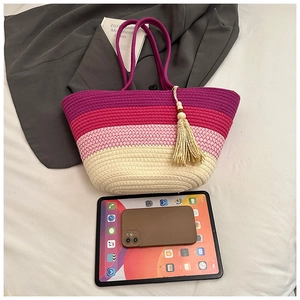Top view of large gradient woven tote with tassels showing its capacity next to gadgets