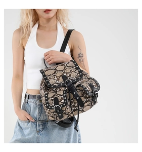 Detailed view of brown snake-skin pattern backpack with silver rivets and buckle straps