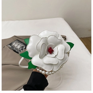 Close-up of white camellia flower crossbody bag with layered petals and pearl strap