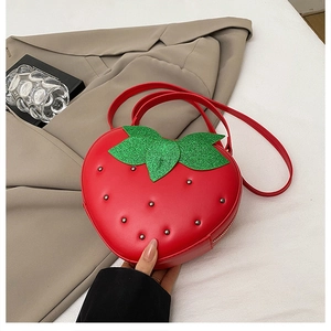 Détail du sac fraise rouge avec rivets argentés et accents de feuilles pailletées