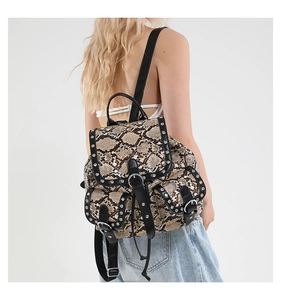 Detail of snake skin print backpack with silver rivets and bohemian flap closure