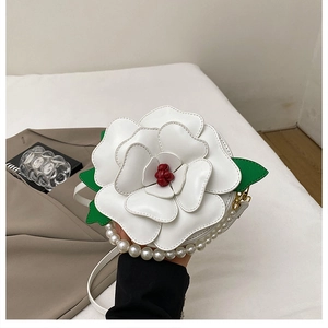 Detail of camellia flower crossbody bag with pearl handle and 3D leather petals