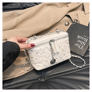 Close-up of white quilted mini vanity bag with crystals and silver rose pendant