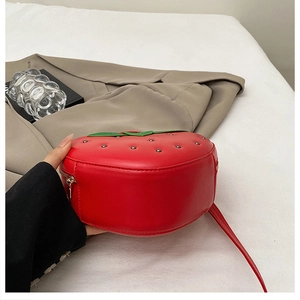 Détails du sac fraise en similicuir rouge avec des feuilles vertes et des rivets argentés