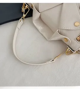 Close-up of beige crocodile pattern bag with jacket collar design and gold rivets