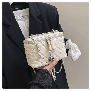 Detail of quilted white crossbody bag with shiny rhinestones and rose zipper pull charm