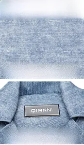 Close-up of denim texture and silver logo plaque on fashionable crossbody bag
