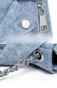 Detail of blue denim shoulder bag with silver studs and polished metal chain link