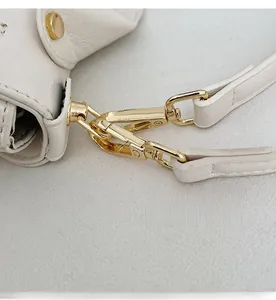 Close-up of golden detachable metal hook and white crocodile pattern leather strap
