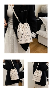 Detail of cream metallic leather bucket bag with silver grommets and drawstring closure