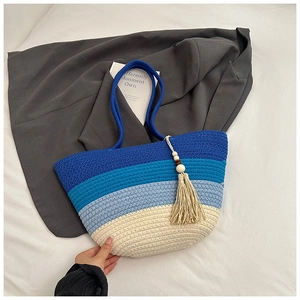 Detail of color-blocked woven tote bag with fringe tassel and wooden beads