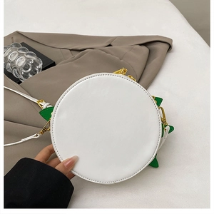 Detail of white round crossbody bag with green leaf accents and gold metal zipper