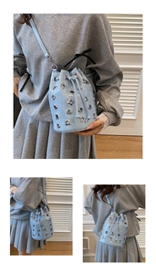 Detail of light blue bucket bag with silver metal eyelets and drawstring closure