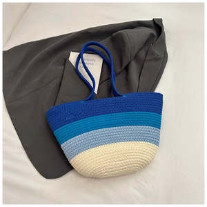 Close-up of woven blue gradient tote bag showing detailed texture and tassels