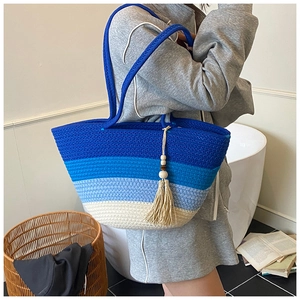 Detail of blue gradient woven tote bag with cotton rope texture and tassel charm