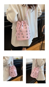 Pink patent leather bucket bag with silver metal eyelets and drawstring closure detail