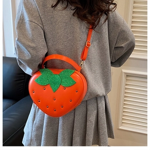 Vue détaillée du sac fraise avec rivets métalliques sur la tenue d'un mannequin