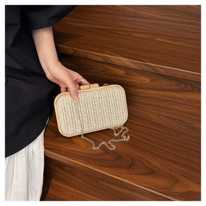 Detail of light beige woven evening bag with V-shaped texture and wooden frame