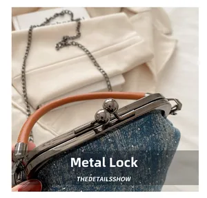 Detailed close-up of the vintage hardware clasp on a starry blue denim shell bag