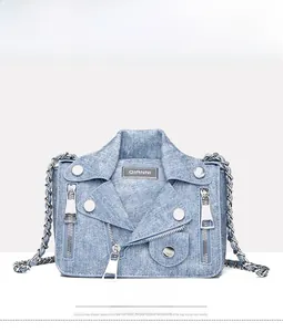 Detailed front view of light blue denim crossbody bag featuring moto jacket design and studs