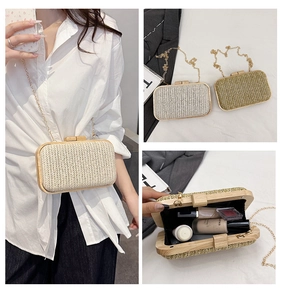 Detail of woven straw box bag featuring a wooden frame clasp and gold chain strap