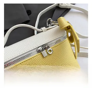 Detail of silver zipper and hardware on yellow lychee texture crossbody bag