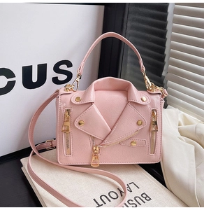 Detail of pink motorcycle jacket style crossbody bag with gold zippers and studs