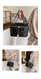 Macro detail of black quilted leather box bag with silver rivets and metal chain strap