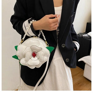 Detail of white 3D flower bag with pearl handle and leather strap on model