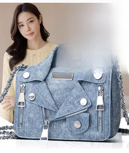 Detail of denim motorcycle jacket cross-body bag with rivets and metal chain strap